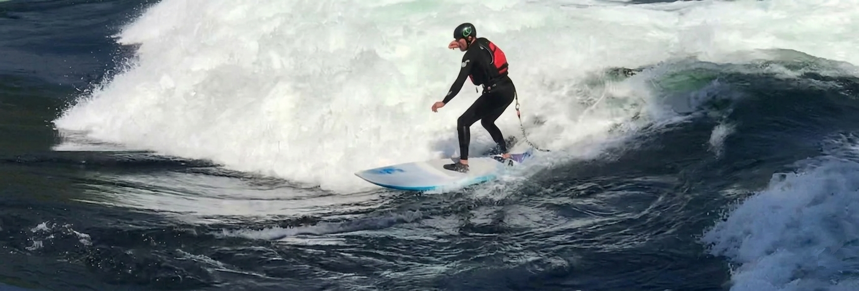 Andy Dressler, Gründer von Kaya Seeds, surft die Eisbachwelle in München